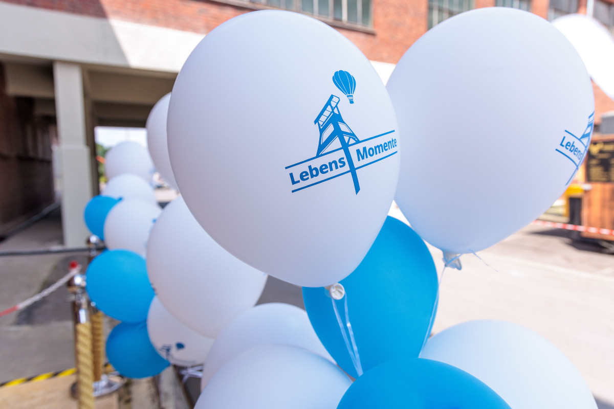 White and blue balloons featuring the "LebensMomente" logo decorate the Lebenshilfe NRW Cultural Festival.