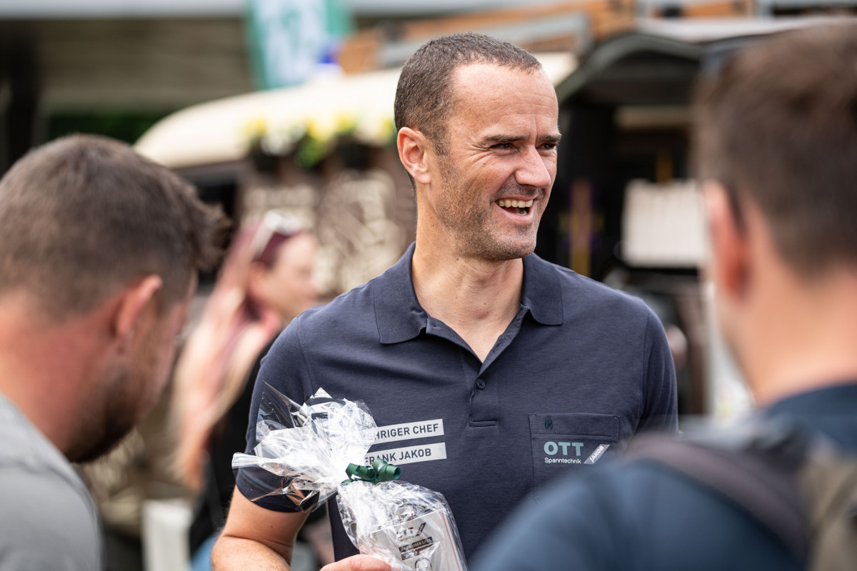 OTT-JAKOB Geschäftsführer Frank Jakob im Gespräch mit Gästen und mit einem Geschenk in der Hand während des Firmenjubiläums.