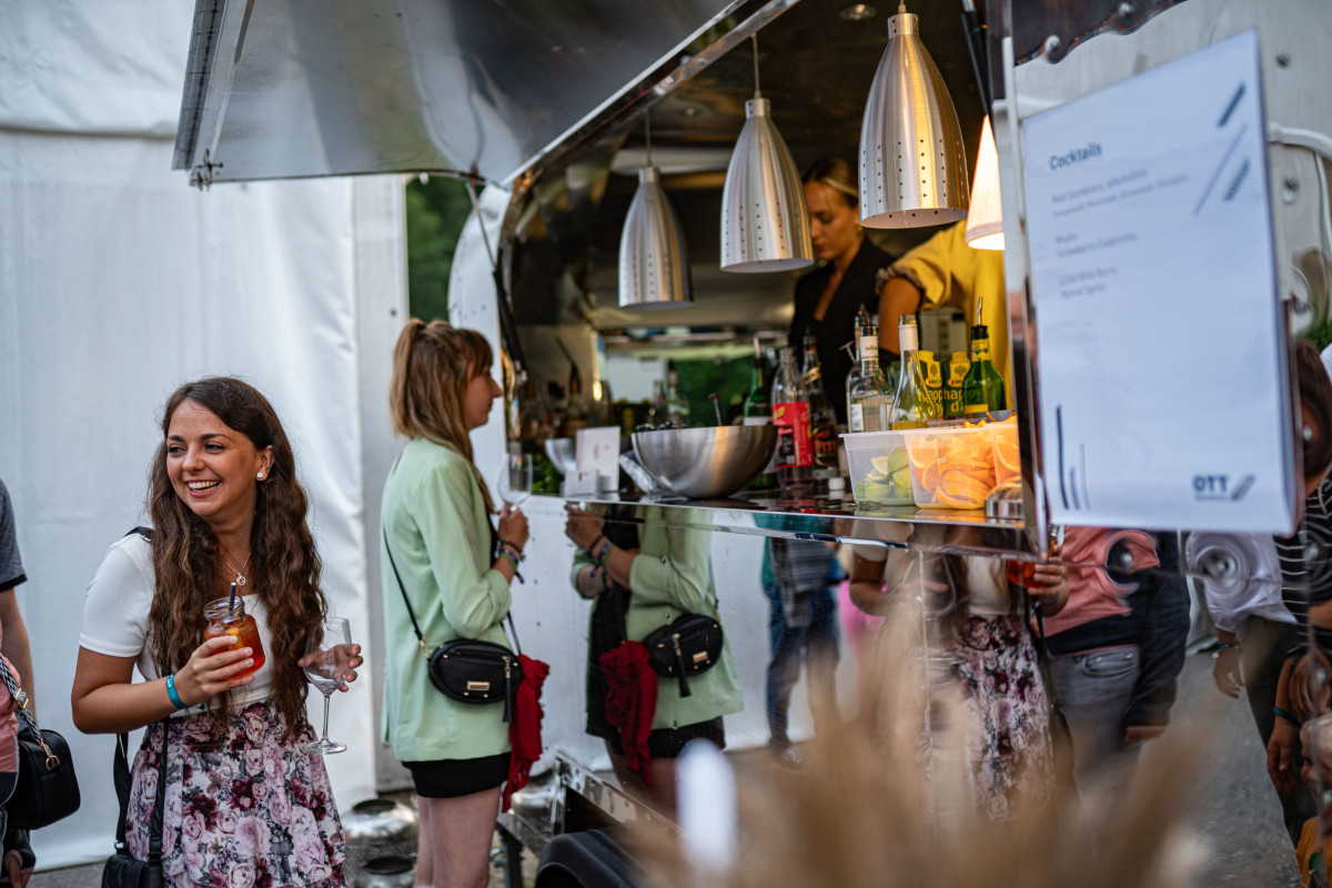Gäste stehen an einem Foodtruck während des OTT-JAKOB Firmenjubiläums im Außenbereich der Veranstaltung.
