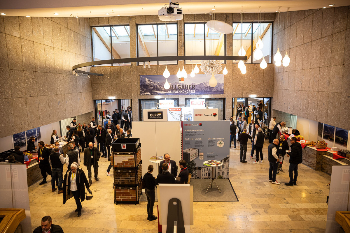 Networking area with information booths and conversations during the construction congress.