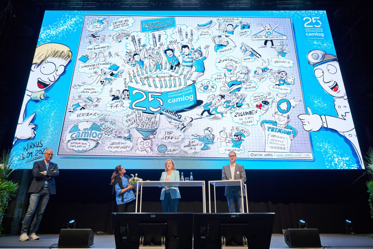 Stage presentation with graphic anniversary visuals.