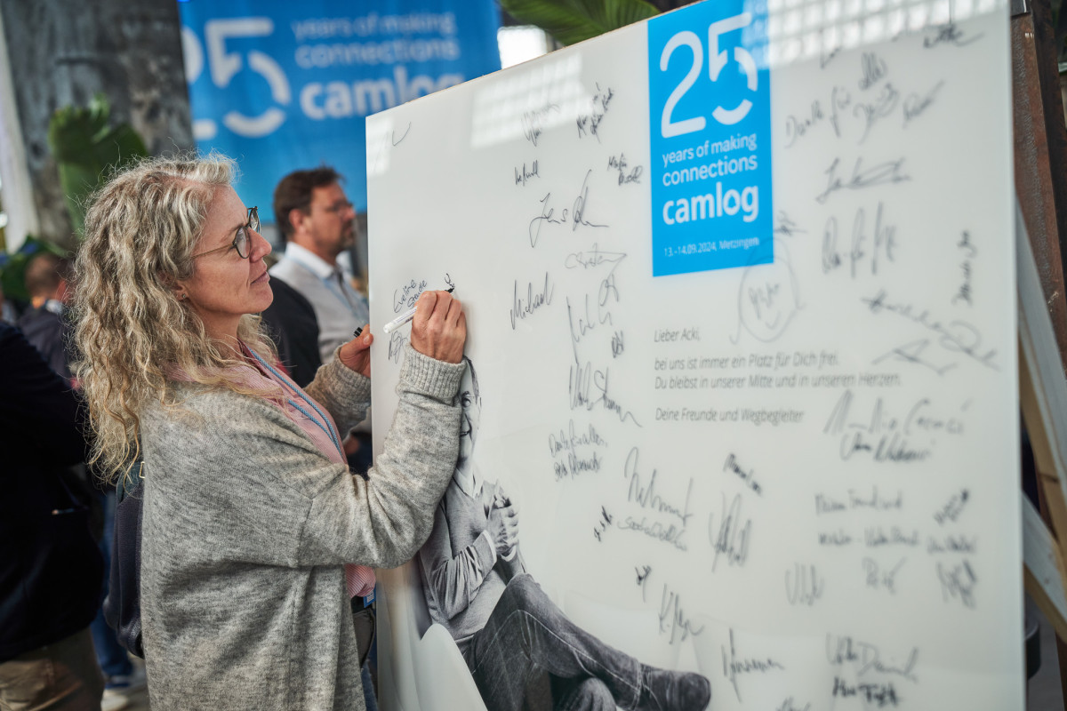 Teilnehmende hinterlassen pers&ouml;nliche Botschaften auf einer Jubil&auml;umswand.