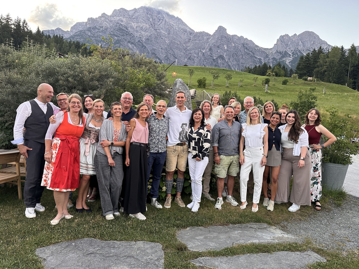 Group photo of participants in front of a mountain panorama.