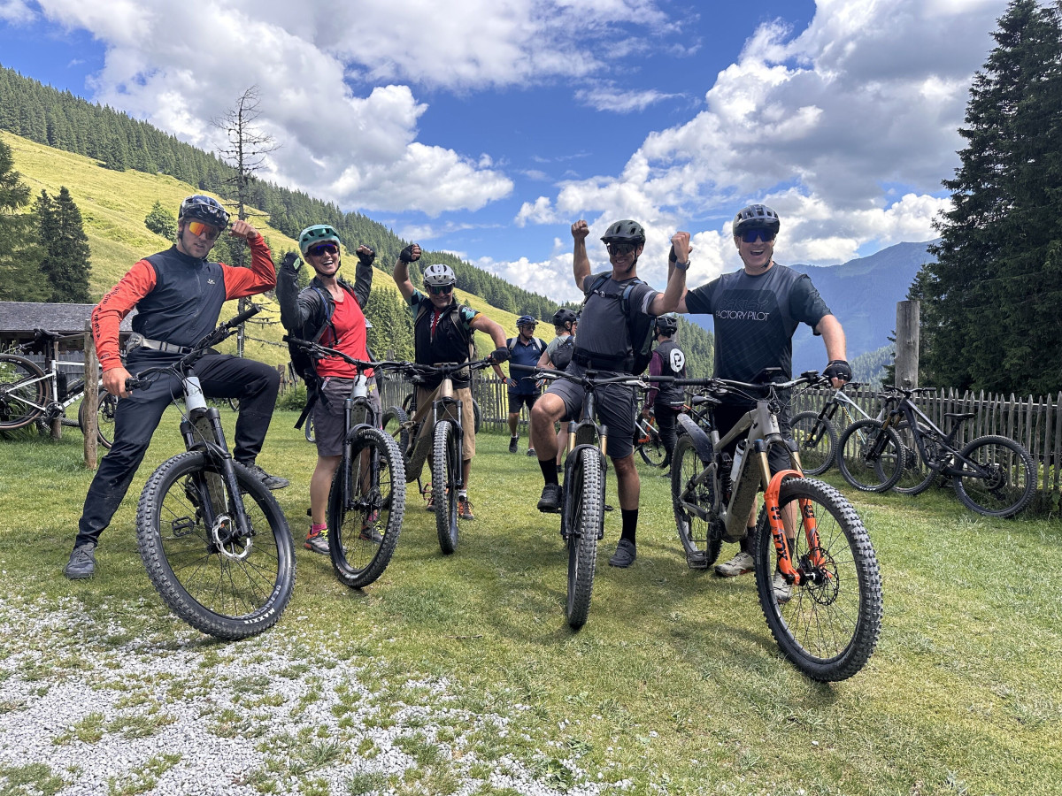 Group of participants with mountain bikes in an alpine landscape.