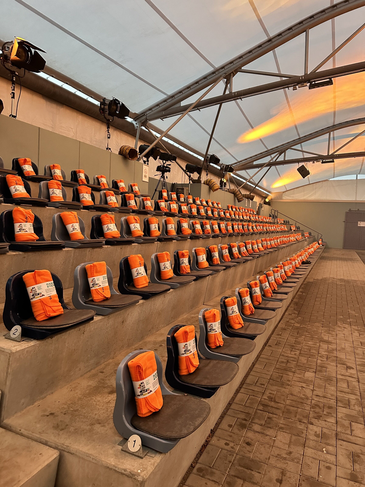 Seated event hall with blankets prepared for guests at the Kubota dealer conference.