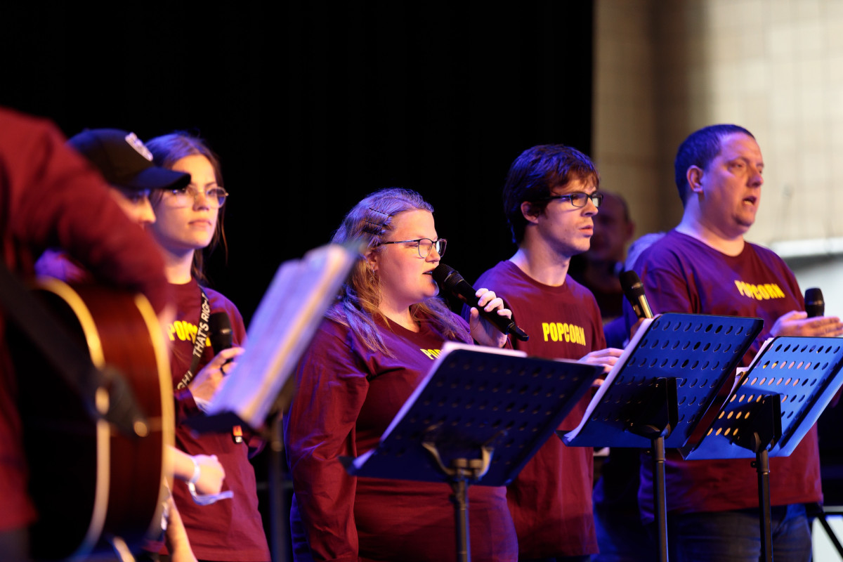 Musicians perform together in front of the audience.