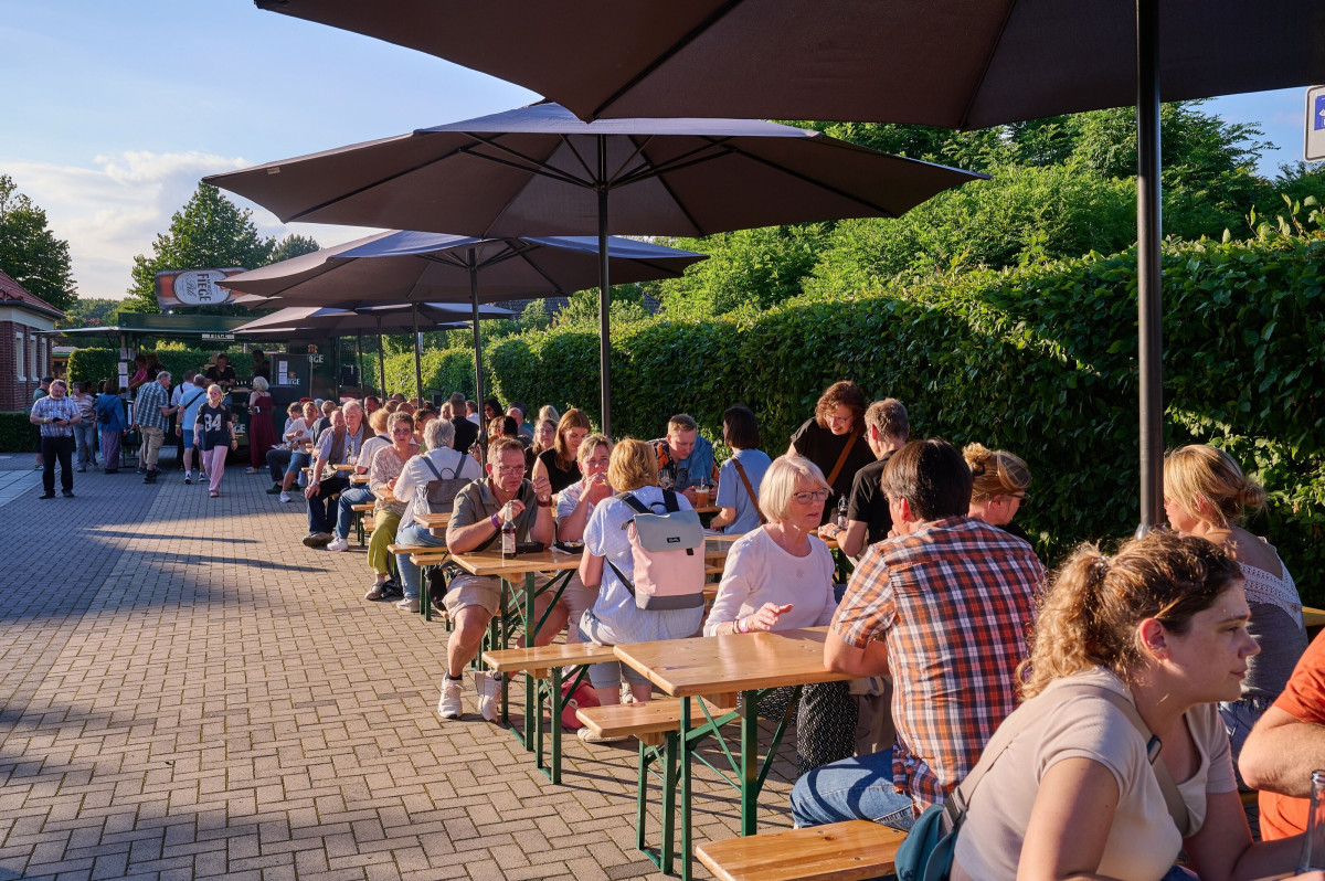Guests sit on beer-garden benches in a relaxed atmosphere.