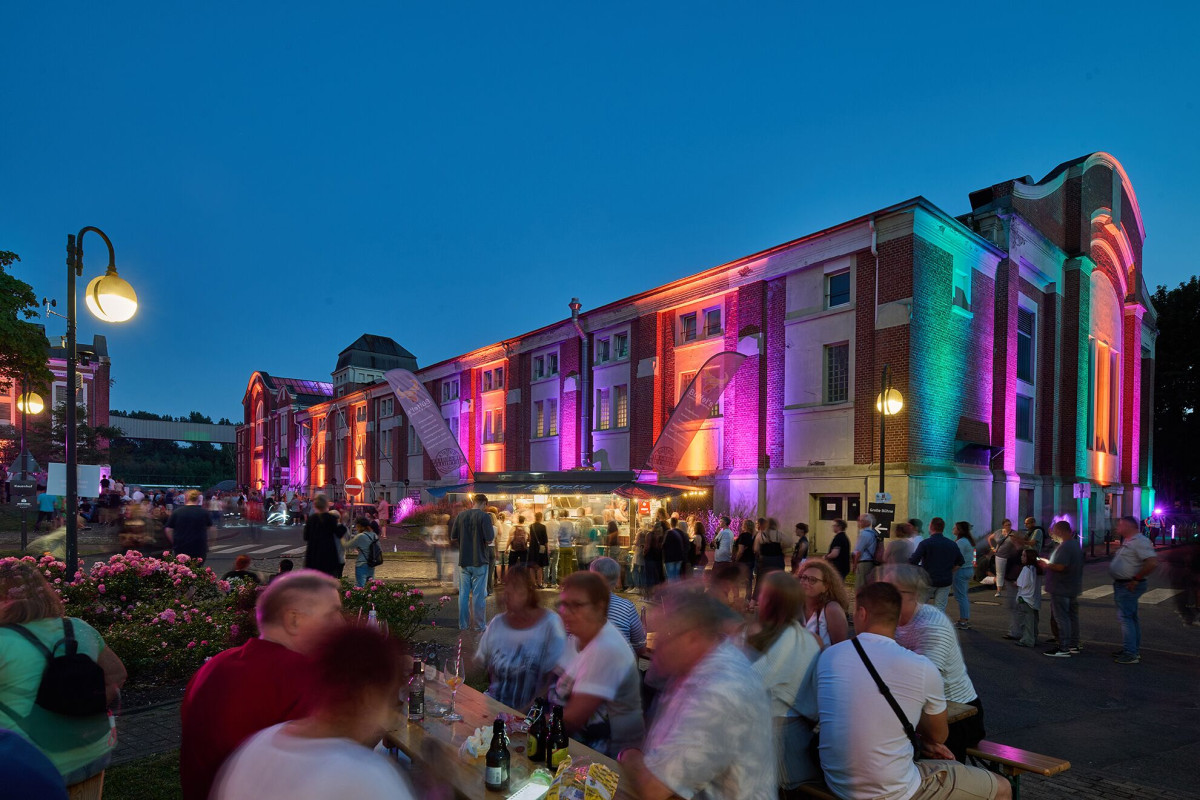 Visitors move through the colorfully illuminated colliery grounds during ExtraSchicht.