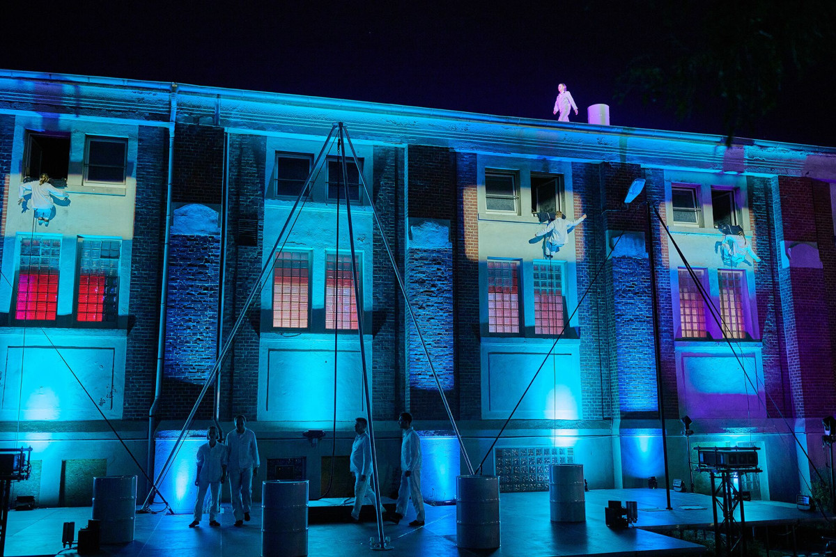 Artists from the Flic Flac association perform live with an unprecedented show in front of the illuminated industrial building.