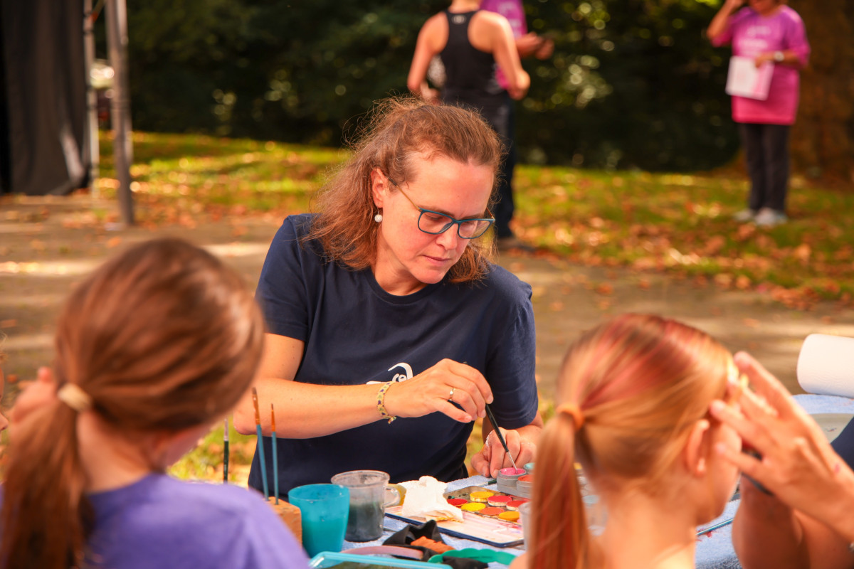 A supervisor runs creative activities with children at the action booth.