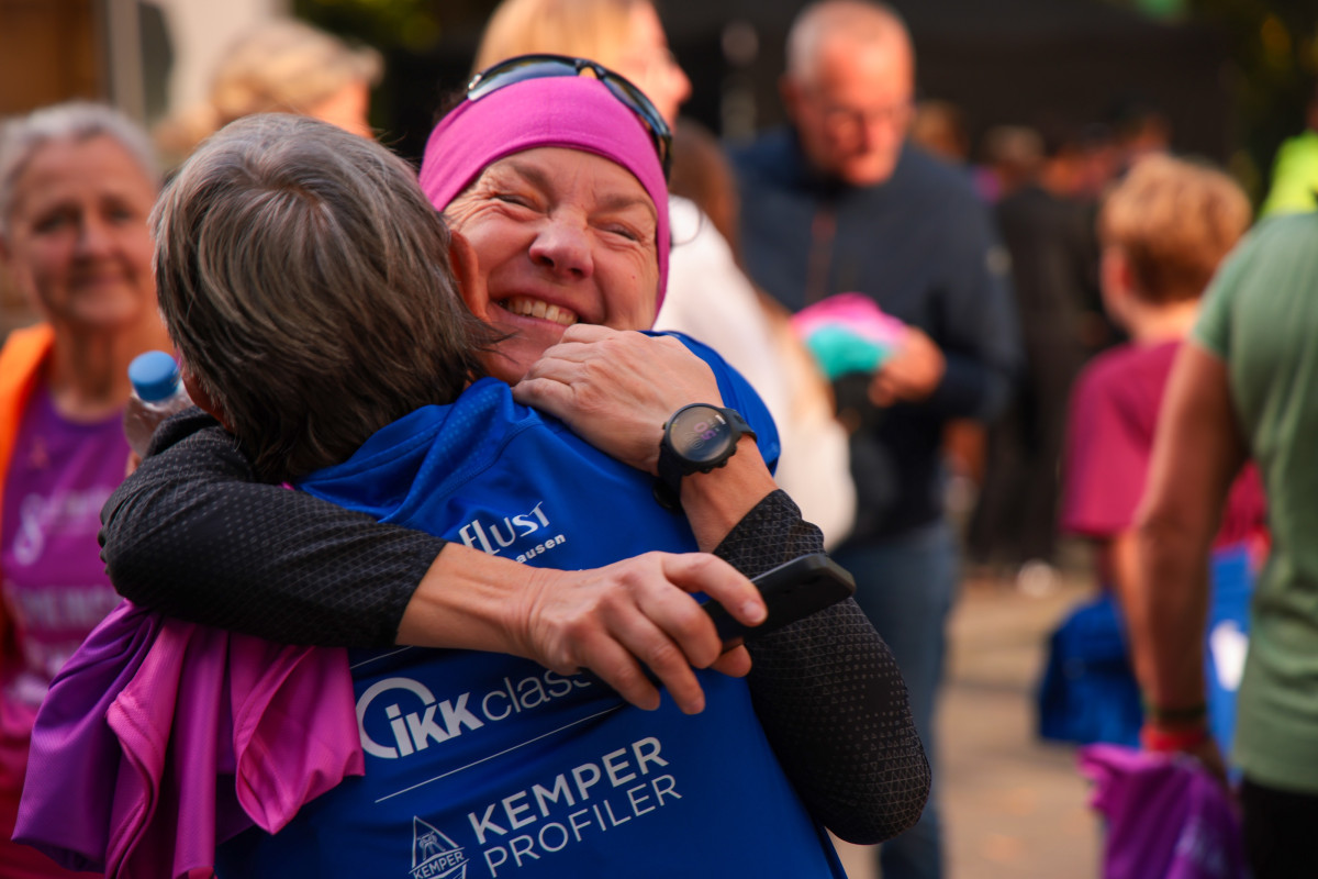 Two participants hug after the run and celebrate the shared moment.