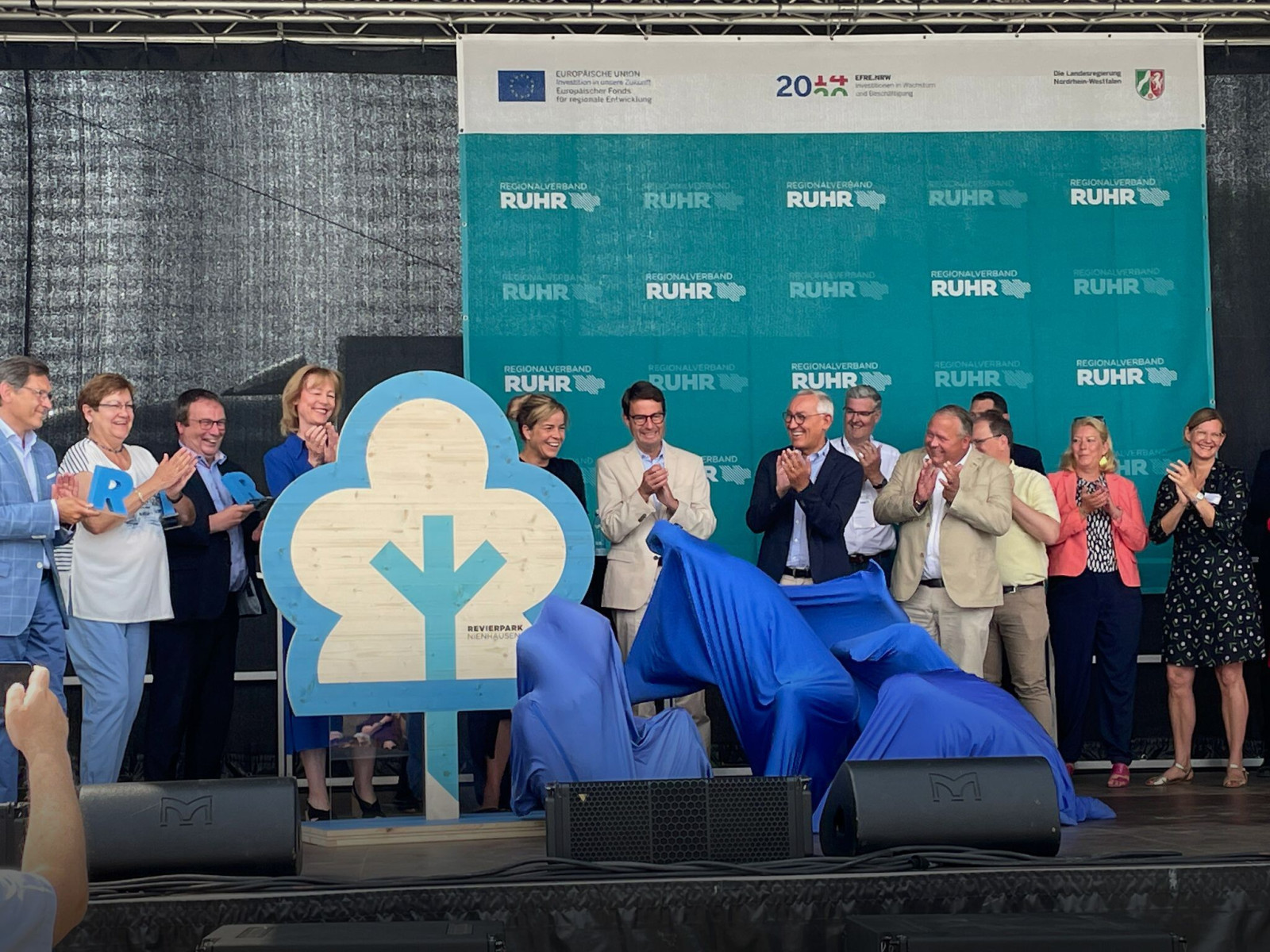 Official opening of a Revierpark with unveiling of the park emblem on stage.