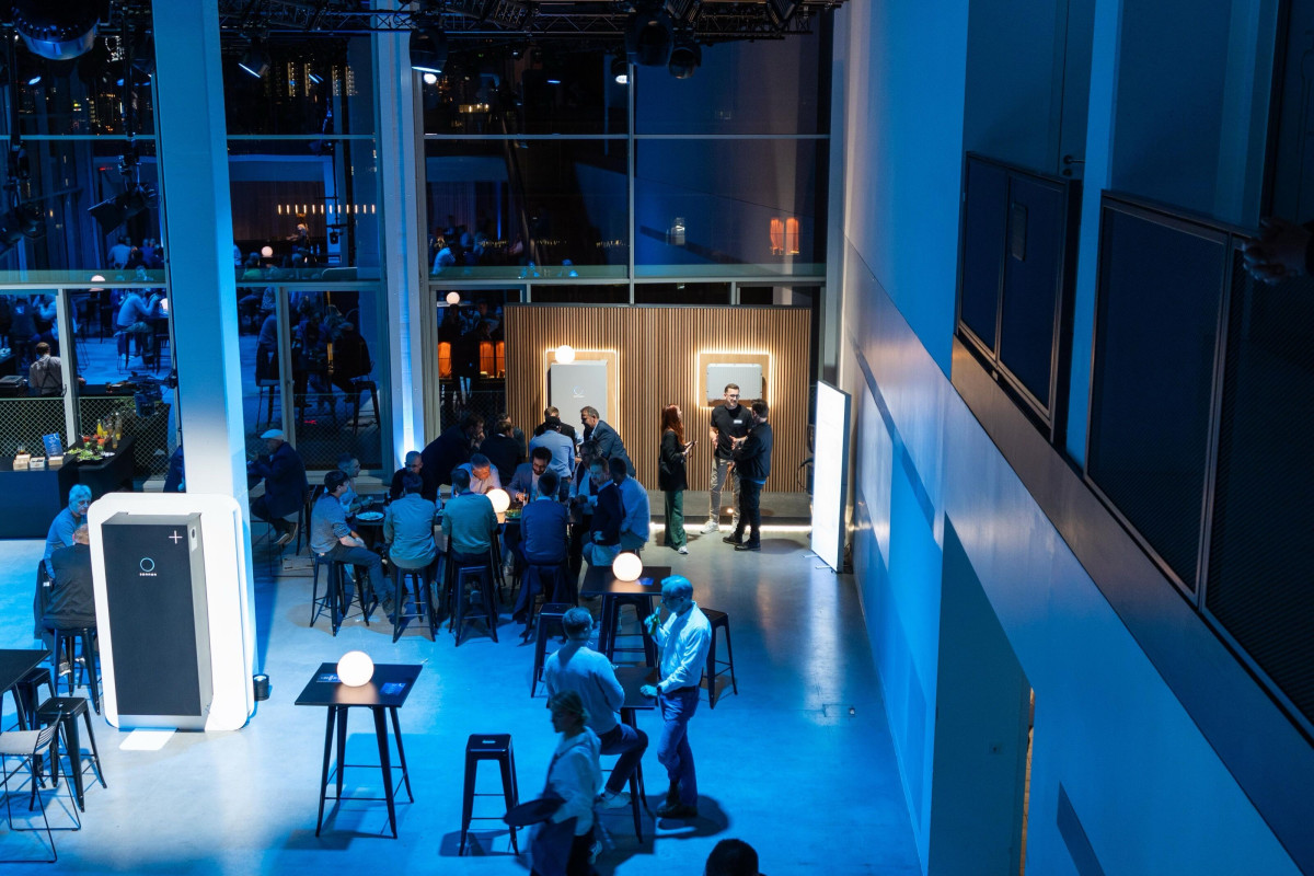 Guests in conversation in the blue-lit venue.