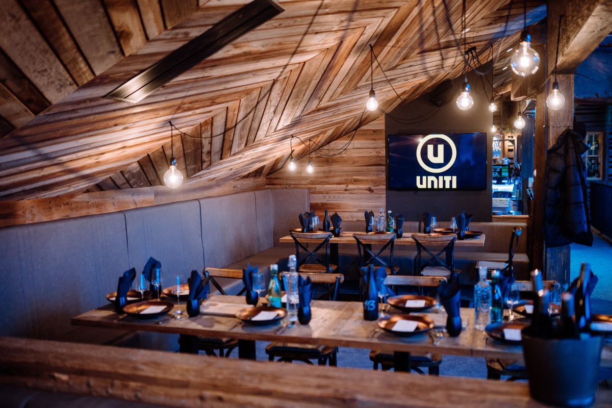 Prepared dinner room with set tables and UNITI branding.